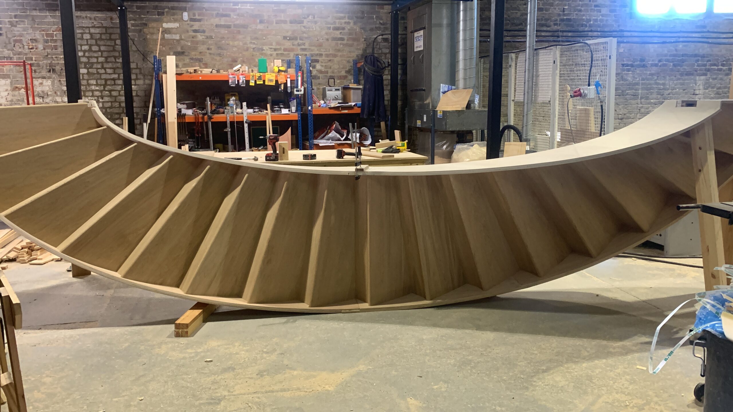 Front view of a bespoke curved oak tread and riser staircase before delivery