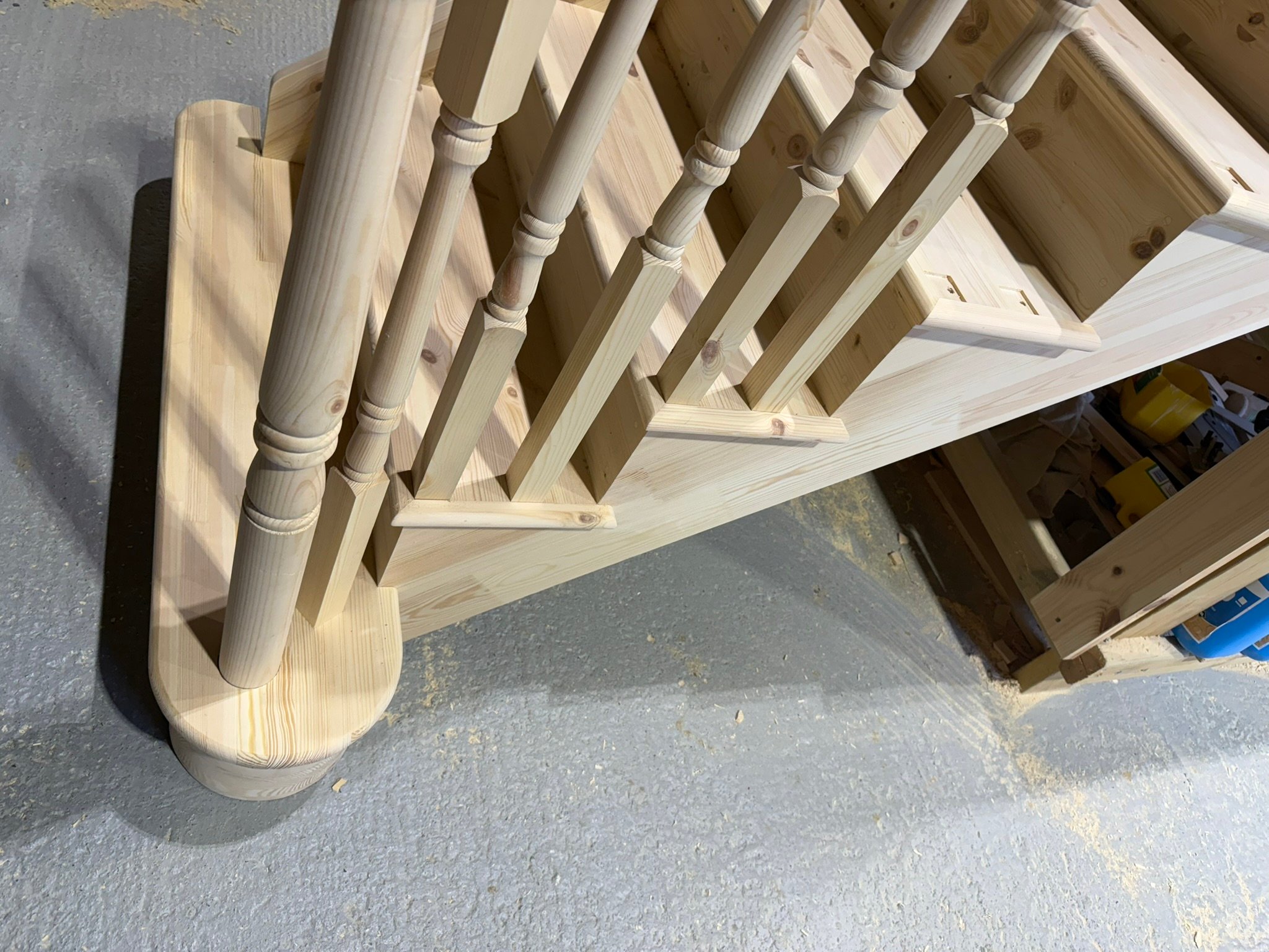 Wooden staircase construction with carved spindles.